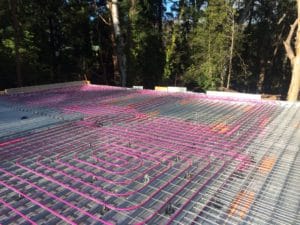 Hydronic pipework tied to the structural mesh of a new home floor slab prior to the concrete pour.